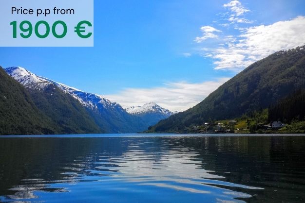 Fjærland fjord in norway with calm water and blue sky as a presentation of "Beautiful scandinavia & the historic Baltics" tour. Price per person from 1900€.