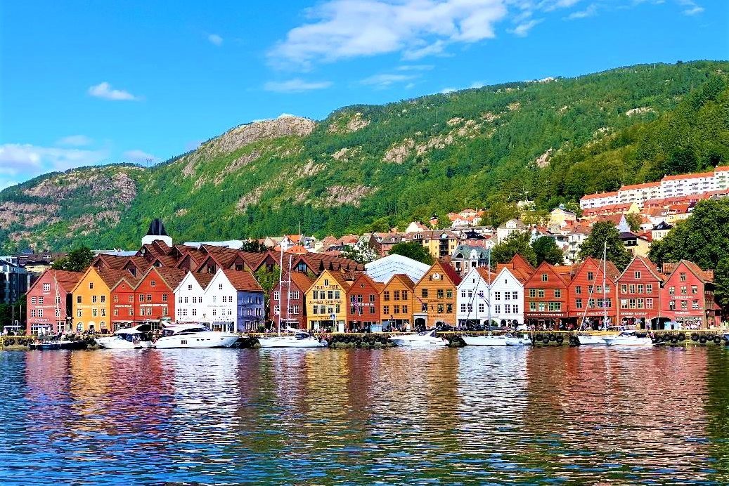 View of Bryggen in Bergen from the seaside on clear day with the mountains in the background