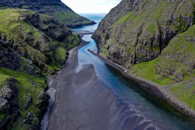 Dried out riverbank between steep mountains