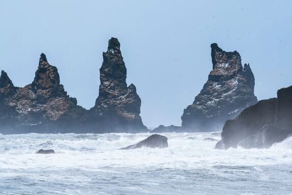 Cliffs in the water with rough waves in Iceland