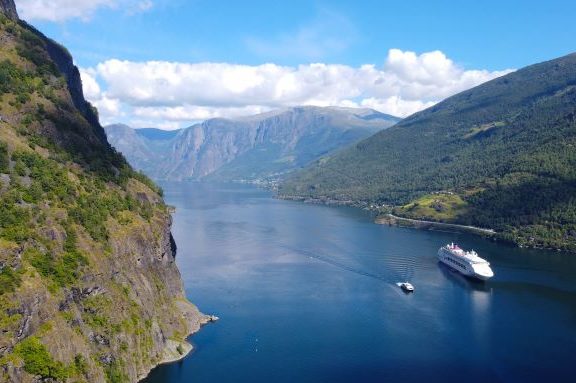 Flåm fjord with a cruise ship sailing on clear water