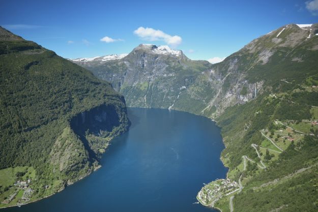 View of Geiranger fjord with sharp road leading down to village by the fjord