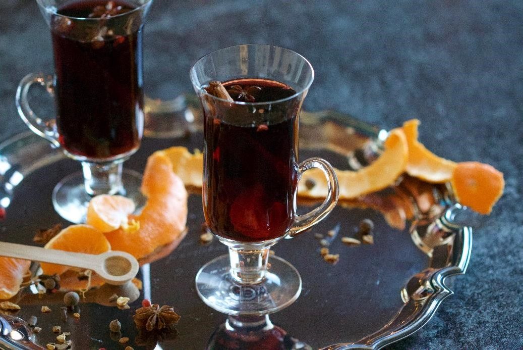 A glass of Glüg wine surrounded with orange peals