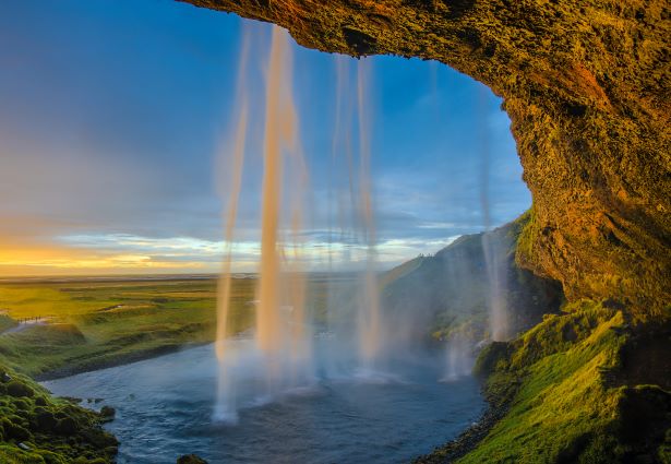 Amazing waterfall in Iceland with the sun setting in clouds