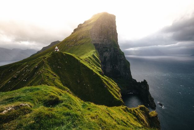 Lighthouse at the top of steep cliff on Faroe Islands