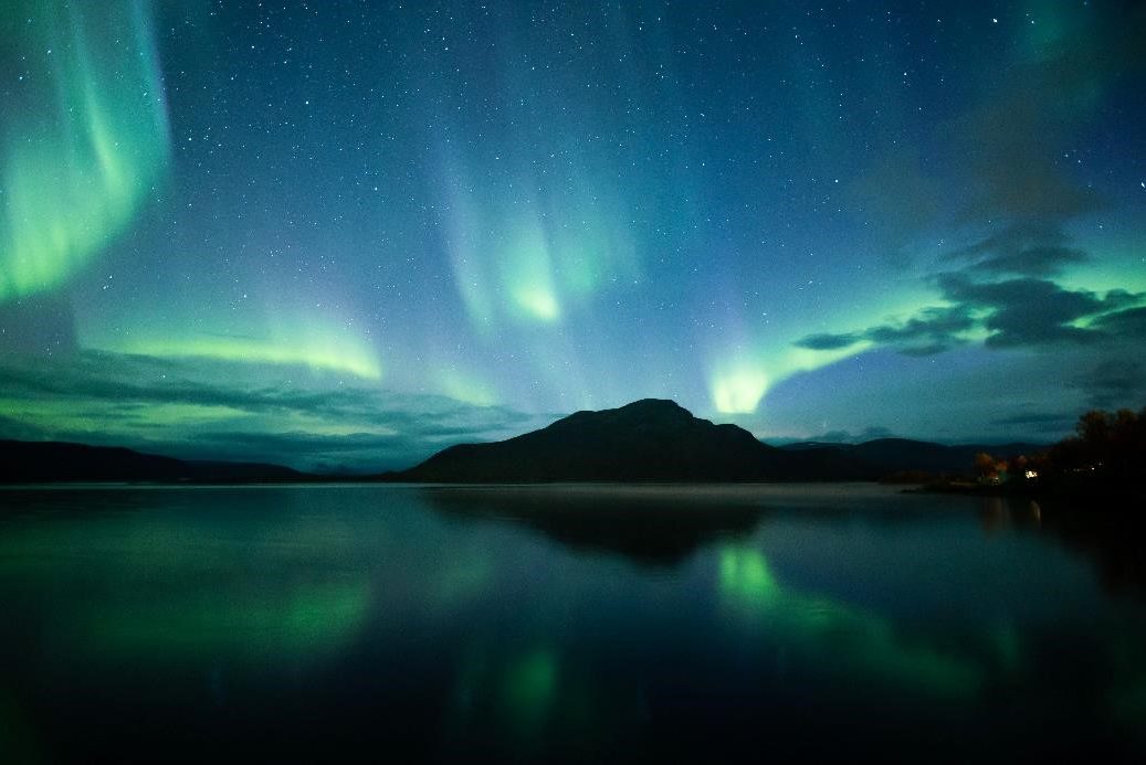 Nothern Lights over lake with mountain in the background