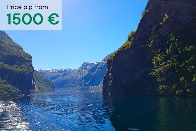 Geiranger fjord on a summer day with clear blue sky and calm water as a presentation of "Norwegian Fjords & Scandinavian Capitals´´ tour. Price per person from 1500€
