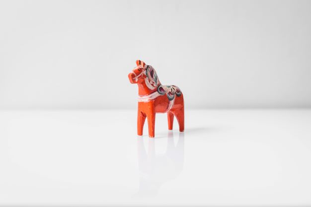 Dala horse in wood painted red with patterns