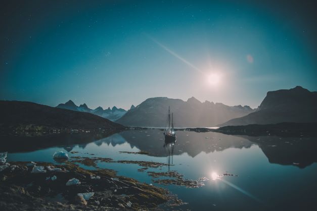 Midnight sun over the fjord with ship