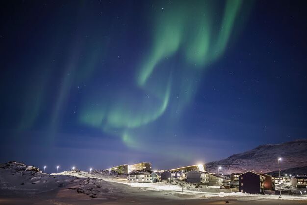 Northern light over village in Greenland